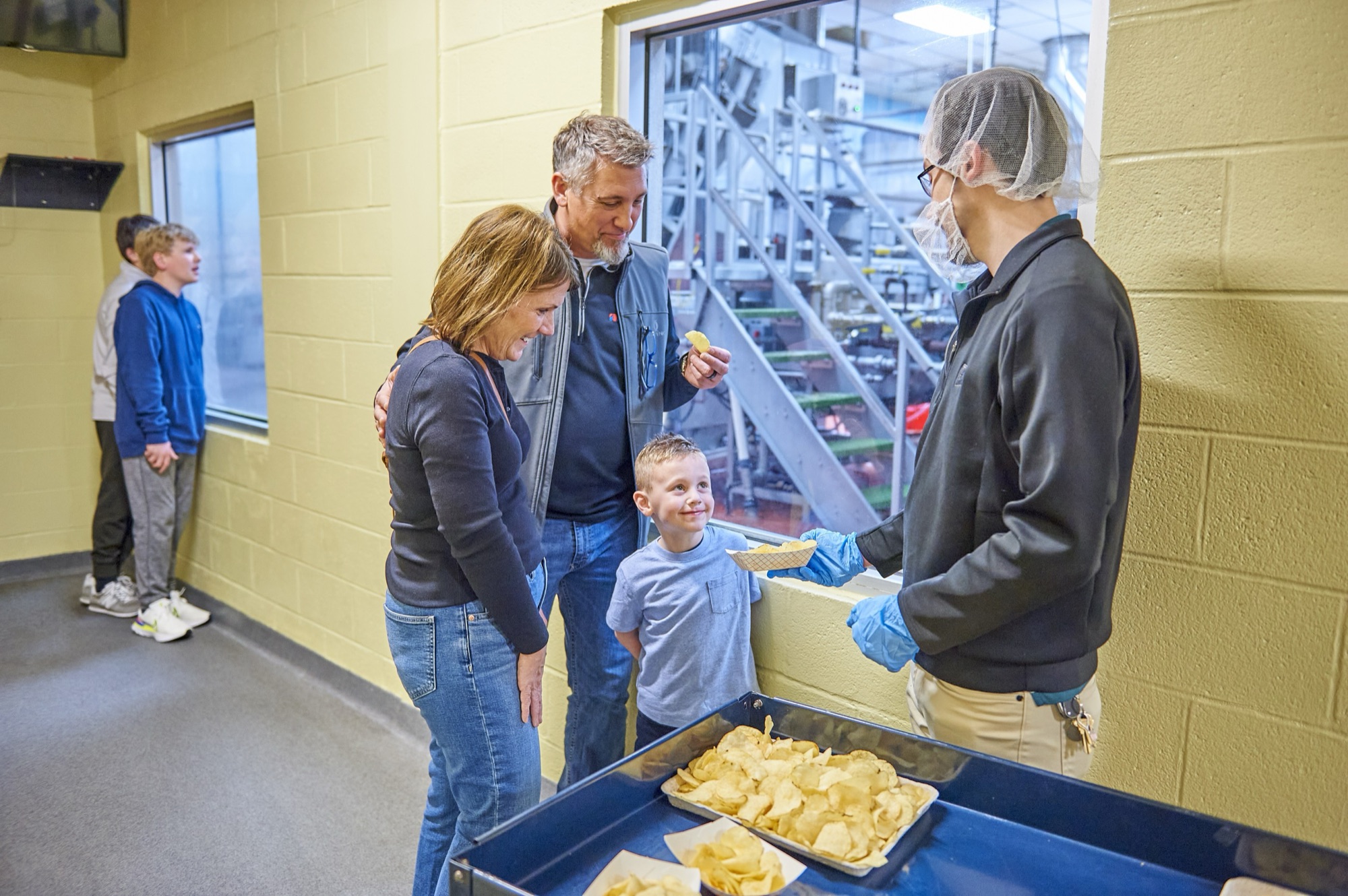 A family tasting fresh Herr's potato chips on the Snack Factory Tour